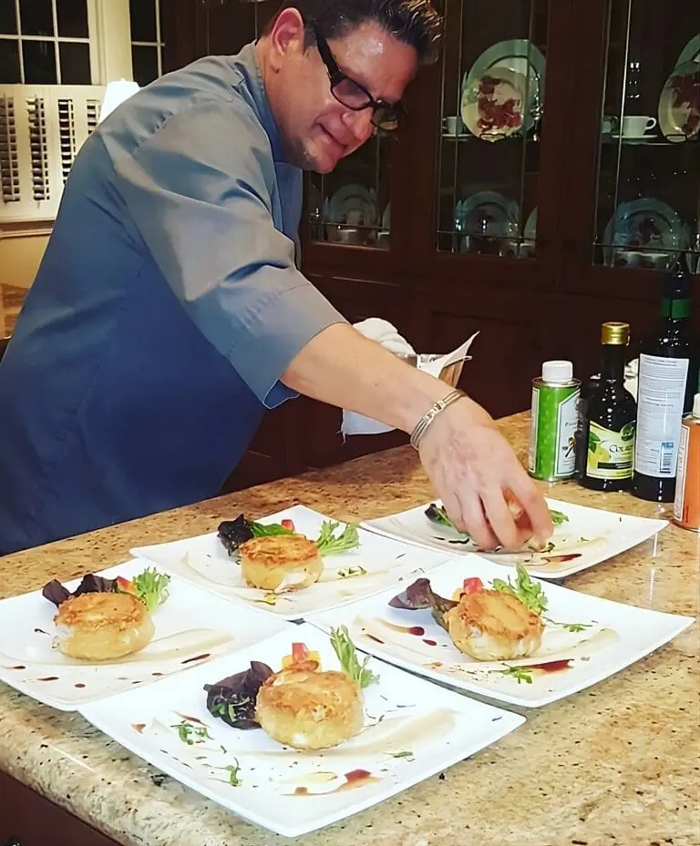 Private chef plating gourmet crab cakes in a luxury kitchen during a fine dining culinary experience in Palm Beach